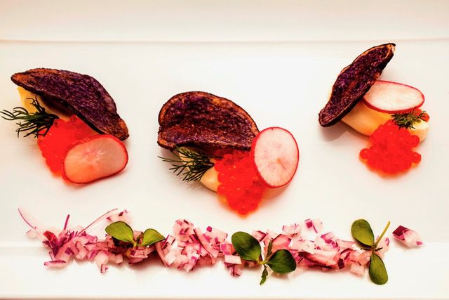Huevas de trucha servidas con crema agria, chips vegetales y eneldo fresco