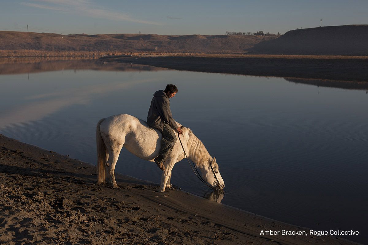 Un hombre abreva a su caballo, un animal central en la cultura sioux.