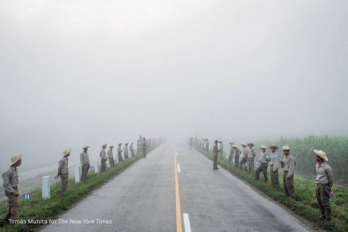 Los miembros del Ejército Juvenil del Trabajo, un ala auxiliar juvenil de las Fuerzas Armadas Revolucionarias, esperan en el camino a Santiago de Cuba al amanecer para que pase el cortejo fúnebre de Castro.