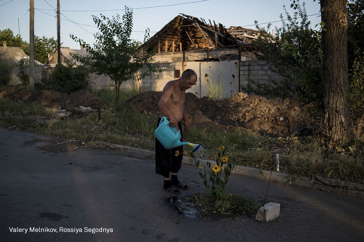 Un hombre riega unas flores en el pueblo de Spartak en julio de 2016.