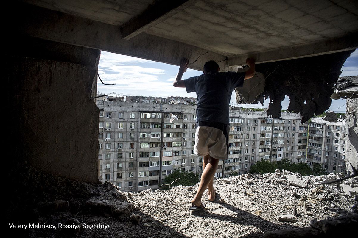 Un hombre inspecciona el daño a un edificio en el distrito Mirny de la ciudad de Luhansk.