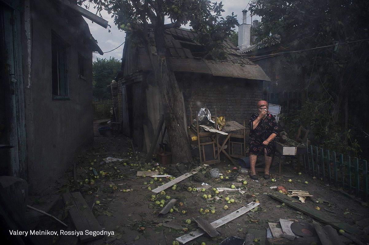 Una mujer se sienta afuera de su casa, golpeada por los bombardeos el 17 de julio de 2014, en Luhansk.