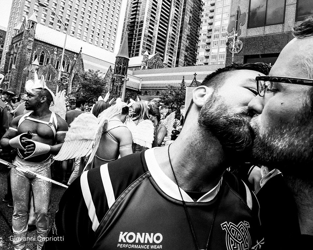 John-Paul Markides (izquierda) besa a su compañero, su compañero de equipo Muddy York, Kasimir Kosakowski, durante el desfile Pride Toronto, el 3 de julio.
