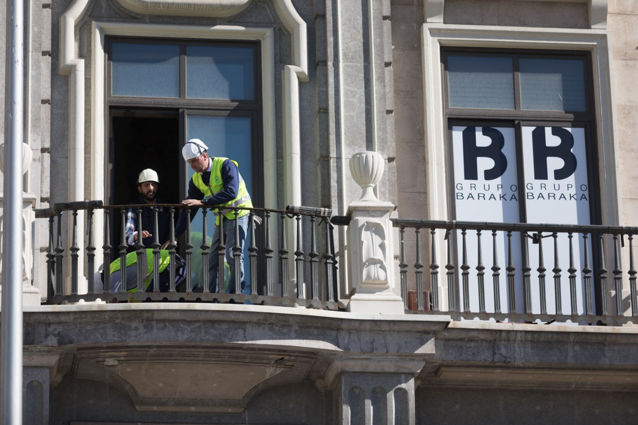 Operarios haciendo agujeros en las terazas del primer piso para fijar los andamios a la fachada.