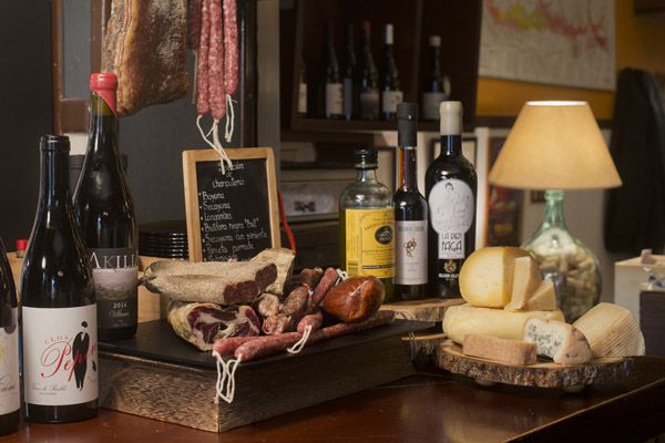 Detalle barra con vino, embutidos y quesos