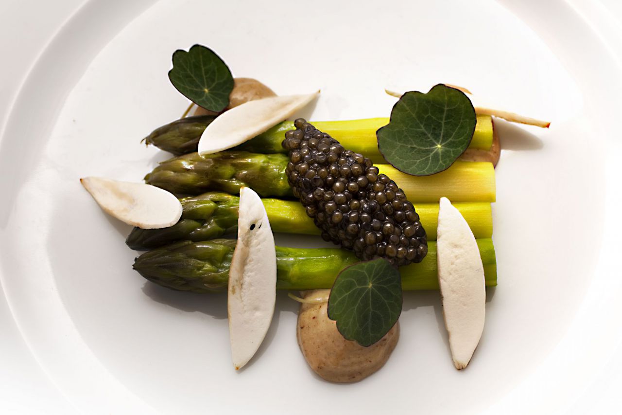Espárragos verdes confitados con caviar sobre mahonesa de setas.