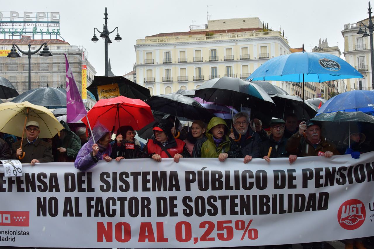 La lluvia no detiene a los pensionistas: la Puerta del Sol inundada por 