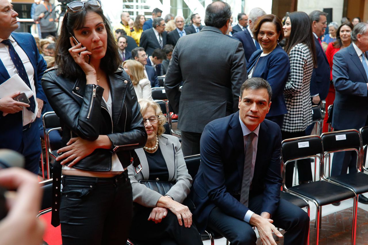 La portavoz del ayuntamiento de Madrid, Rita Maestre, habla por teléfono cerca del secretario general del PSOE, Pedro Sánchez.