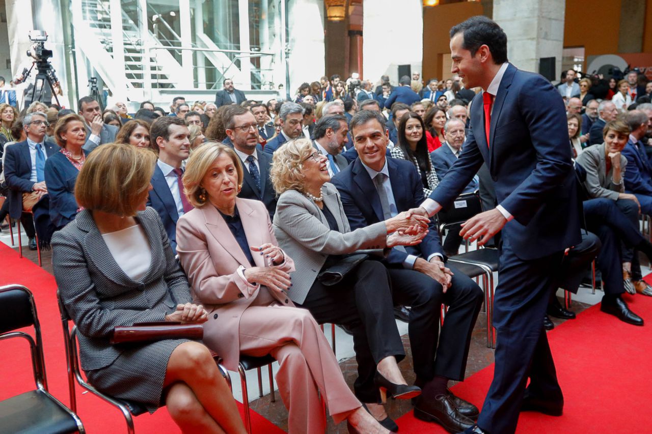 El portavoz de Ciudadanos en la Asamblea de Madrid, Ignacio Aguado, saluda a la alcaldesa de Madrid, Manuela Carmena, bajo la atenta mirada del secretario general del PSOE, Pedro Sánchez.