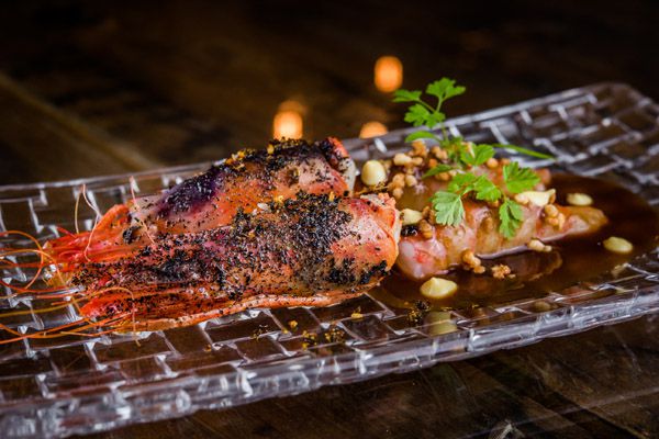 Gamba roja con jugo de cochinillo y mayonesa de ajo negro.