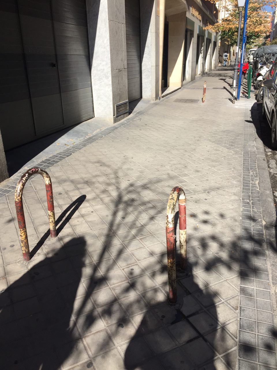 Bolardos en la acera que interrumpen el paso peatonal en calle Covarrubias, 19.