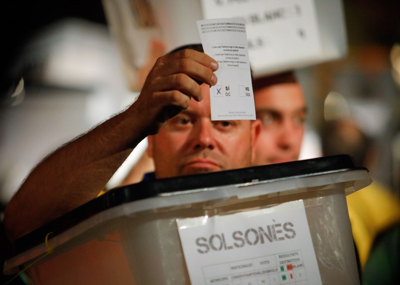 Un manifestante porta una urna que se utilizó en el referéndum.