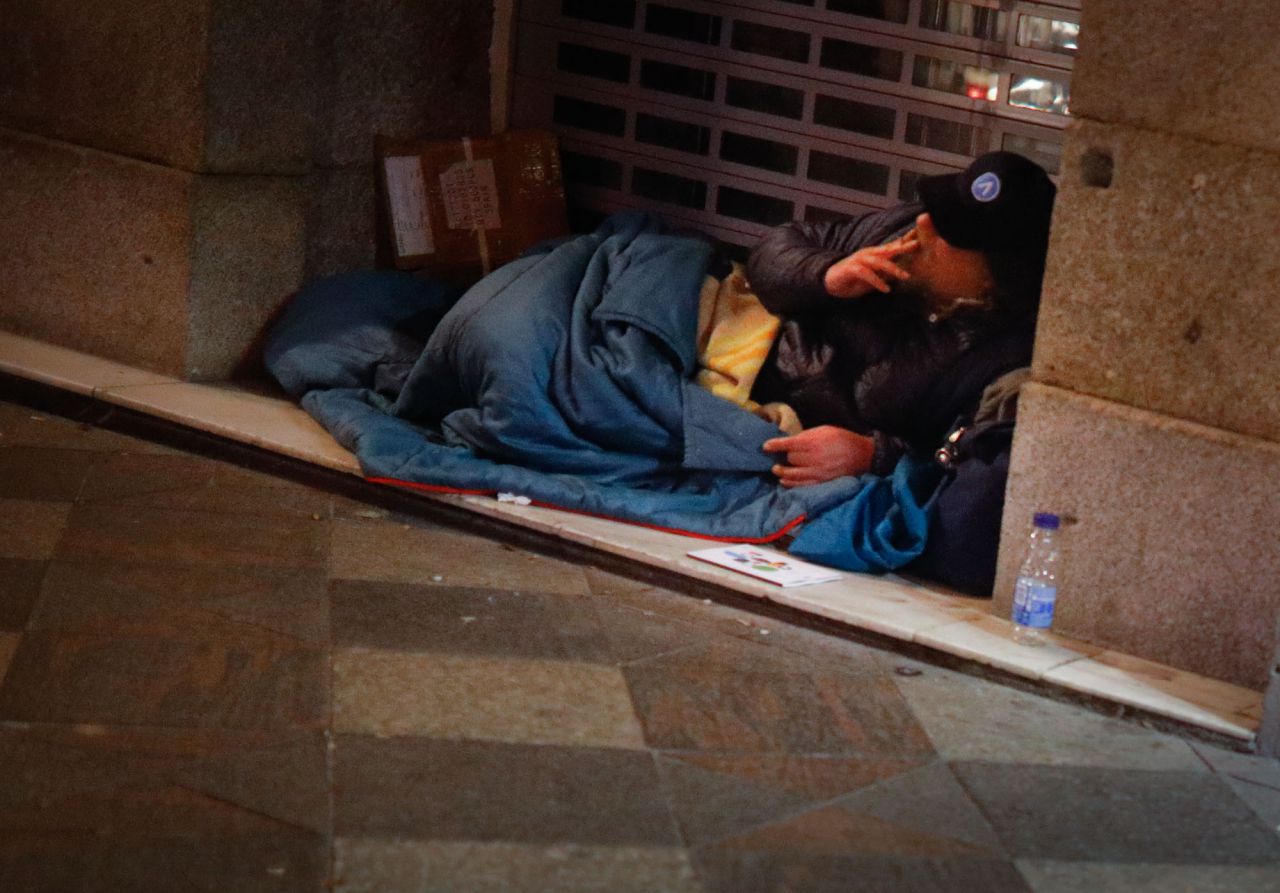 Una persona fuma un cigarro en la puerta de un comercio de la calle Arenal.