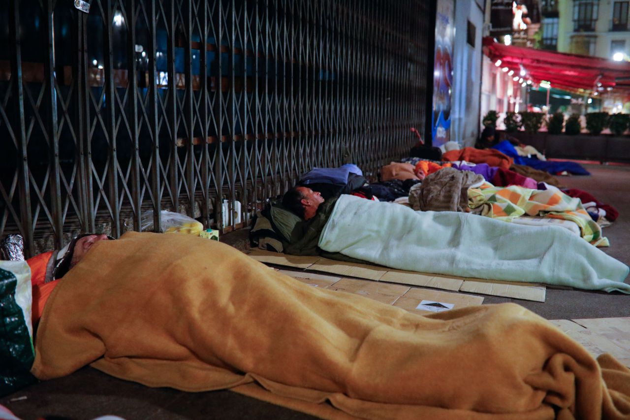Más de veinte personas duermen a las puertas del teatro cine Real Cinema en la plaza de Isabel II, frente al Teatro Real.