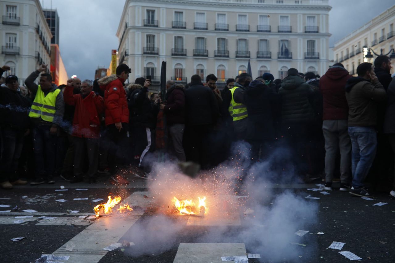Los taxistas queman una camiseta con la imagen de Ángel Garrido frente a la Casa de Correos en Sol. 