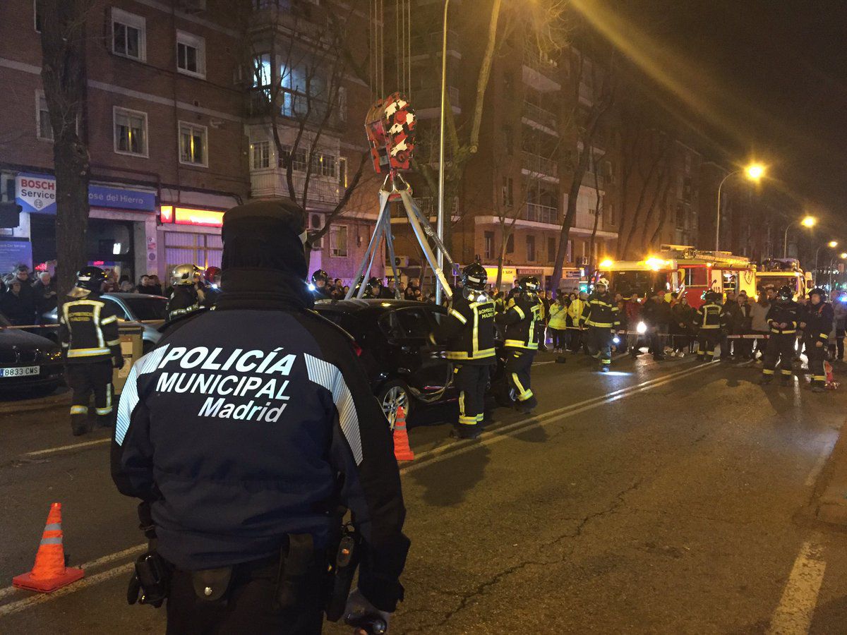 Los Bomberos sacan los dos turismos atrapados en el socavón de Ciudad Lineal con la ayuda de una grúa. 