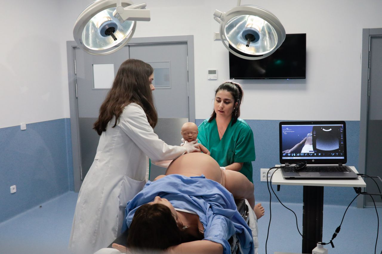 Dos alumnas de la UAX practican cómo actuar en un parto en el Hospital de Simulación Virtual.