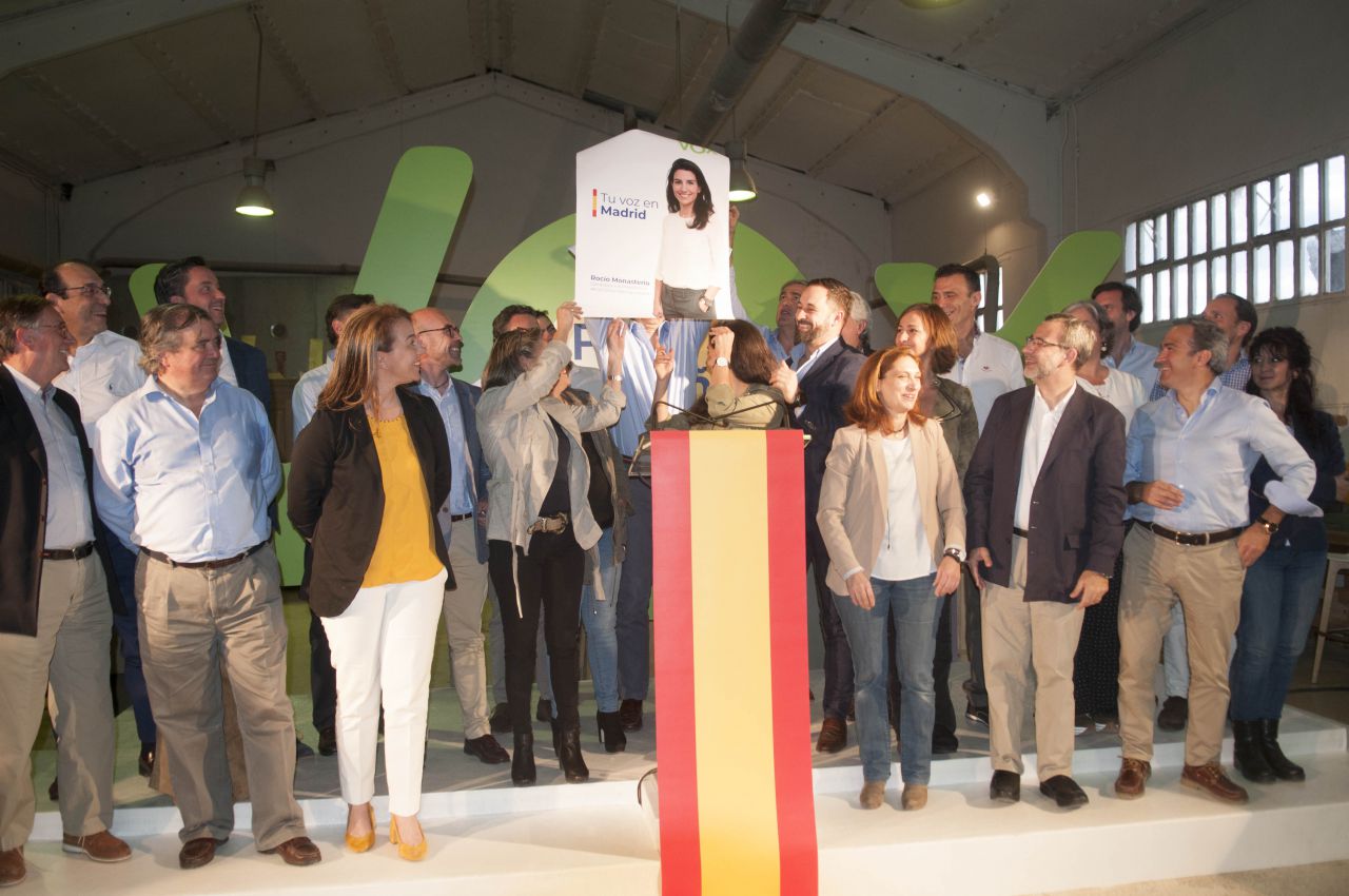 Los miembros de Vox, con el cartel electoral de Rocío Monasterio. 