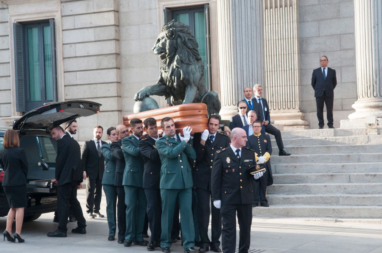 Miembros de la Guardia Civil y la Policía cargan a hombros el féretro del exministro del Interior. 