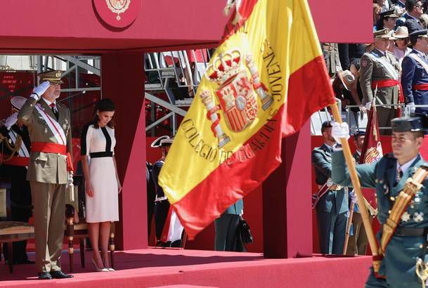 Sus Majestades los Reyes durante el desfile terrestre al paso de la enseña nacional