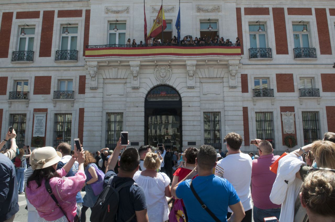 Asistentes a la Puerta del Sol observan la copa ofrecida por las jugadoras del Atlético de Madrid femenino