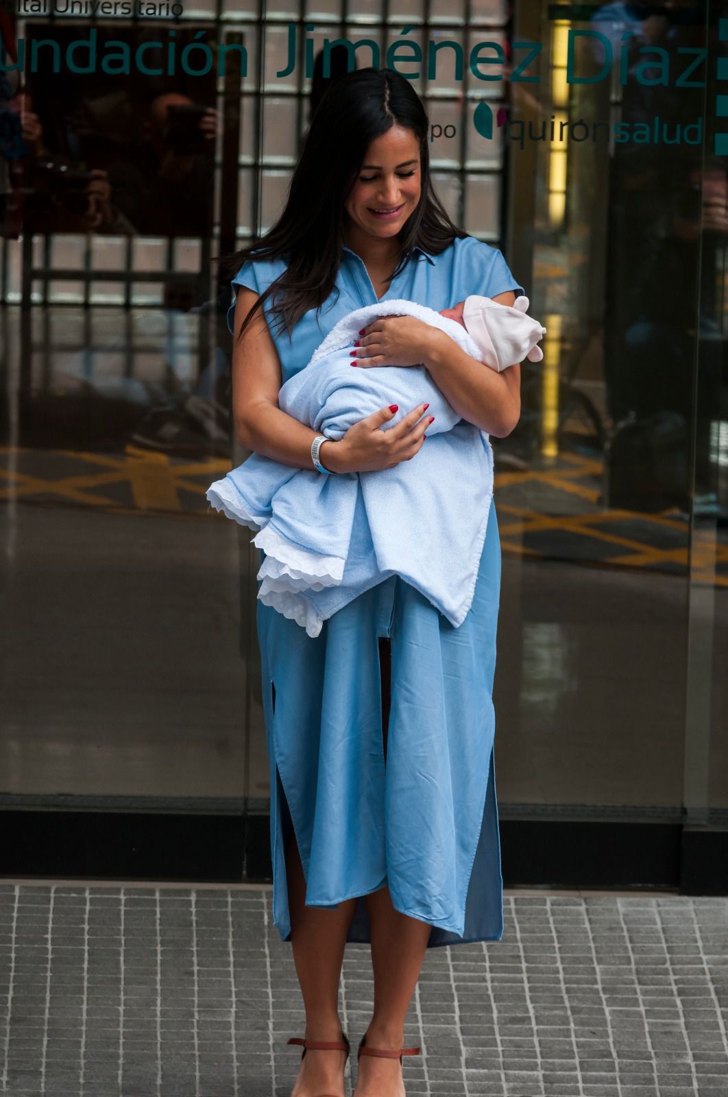 Vestida con un vestido largo denim con un lazo atado a su cintura y sujetando a su pequeña en los brazos, la política madrileña ha dado unas palabras a su salida del centro hospitalario.