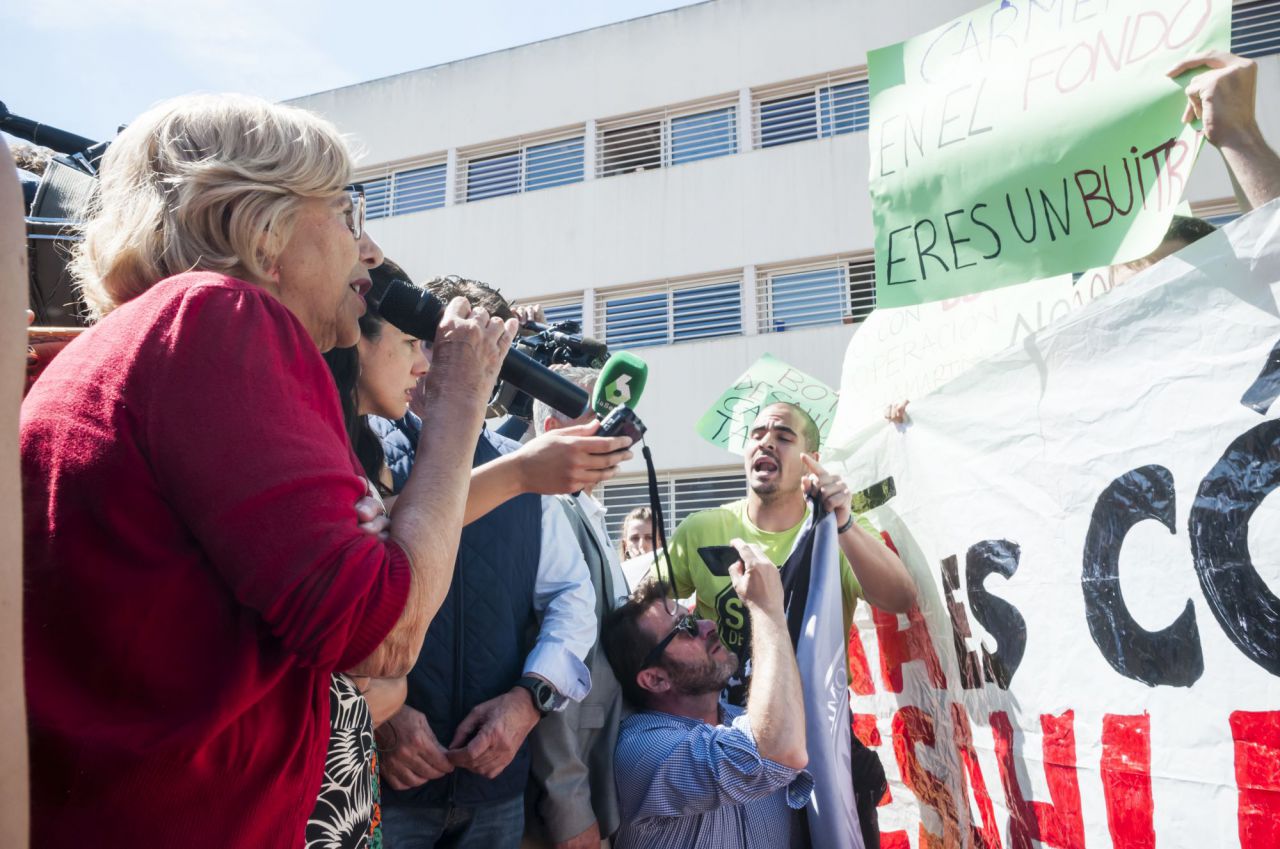 Manuela Carmena intenta dialogar con un grupo de personas que interrumpe un acto de campaña de Más Madrid en Moratalaz