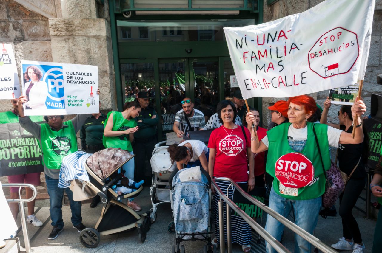 En una de las entradas, numerosas personas sujetando pancartas y gritando proclamas.