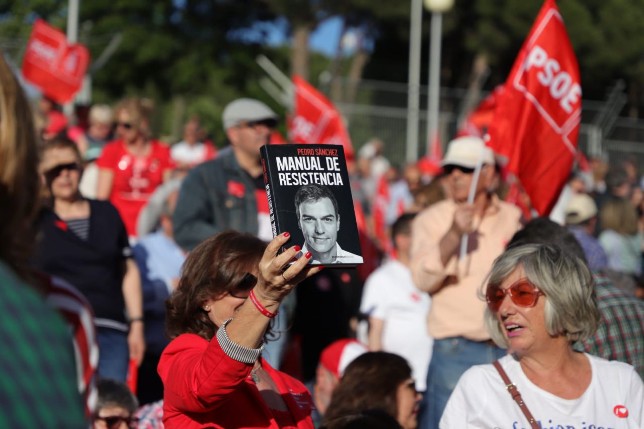 Una mujer levanta el libro de Pedro Sánchez 'Manual de resistencia'.