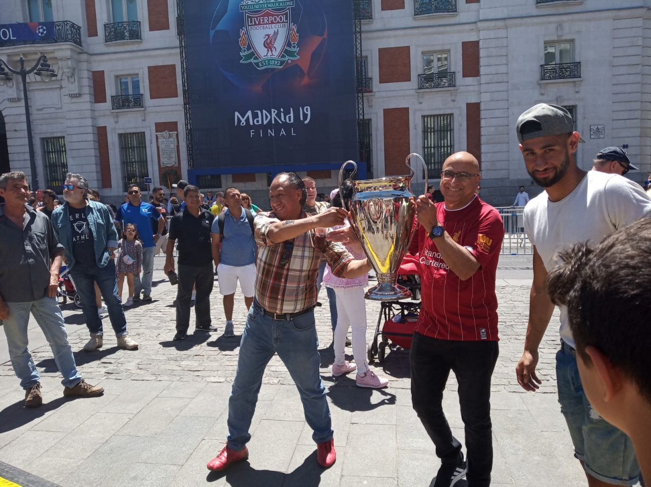Aficionados, en el Puerta del Sol, con una reproducción del trofeo de la Champions