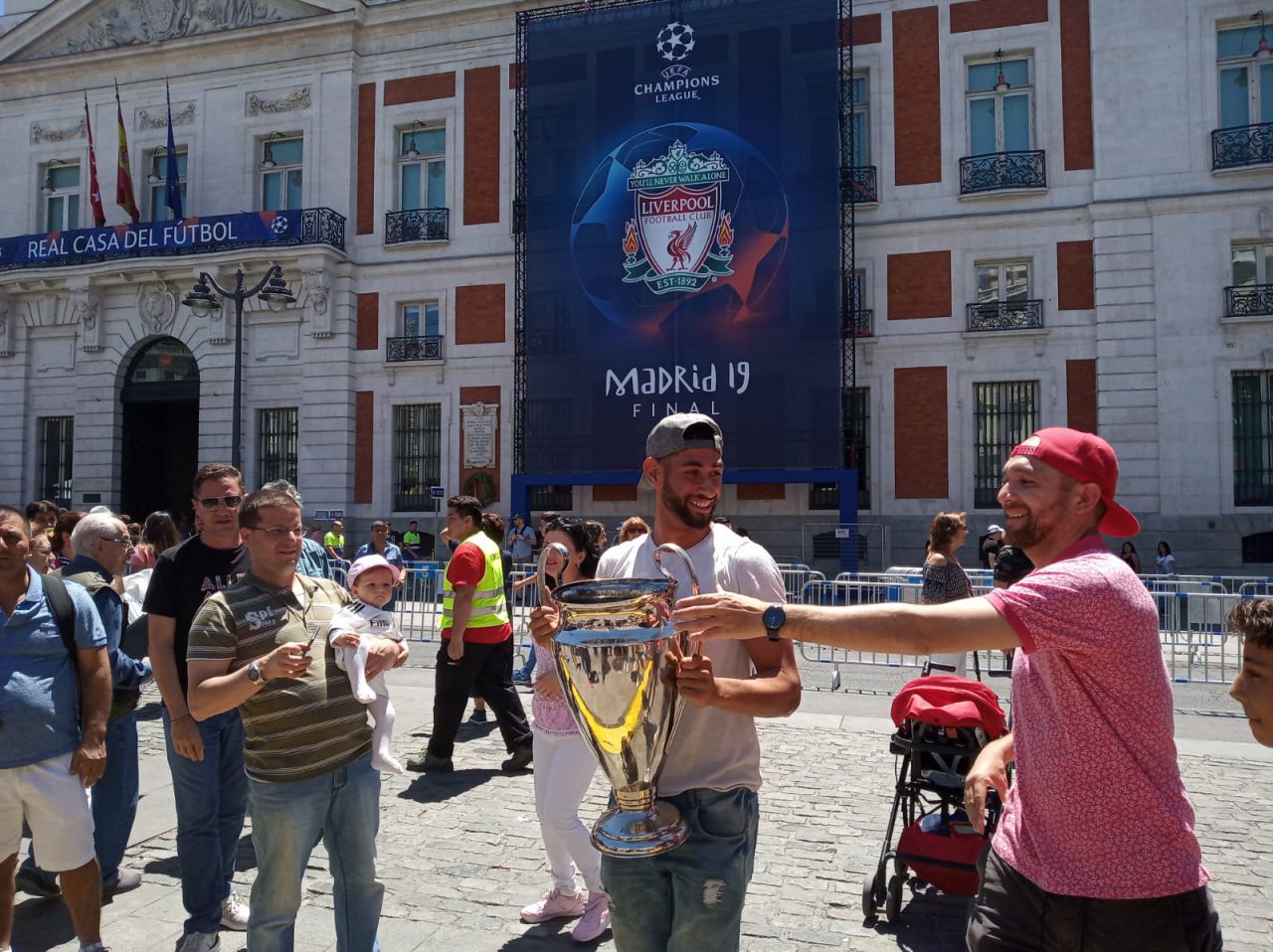 Aficionados, en el Puerta del Sol, con una reproducción del trofeo de la Champions