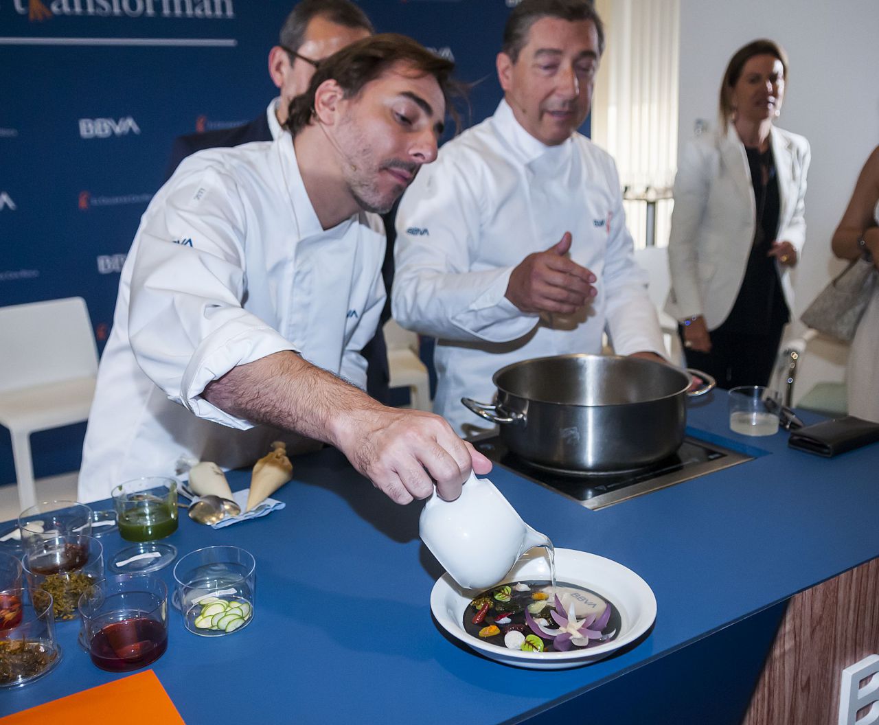 Gracias a un principio cromotérmico del plato, la sopa que ha acompañado a la flor de cebolla y las flores y tallos encurtidos ha cambiado de color el fondo, donde ha aparecido la nueva identidad de marca de BBVA. 