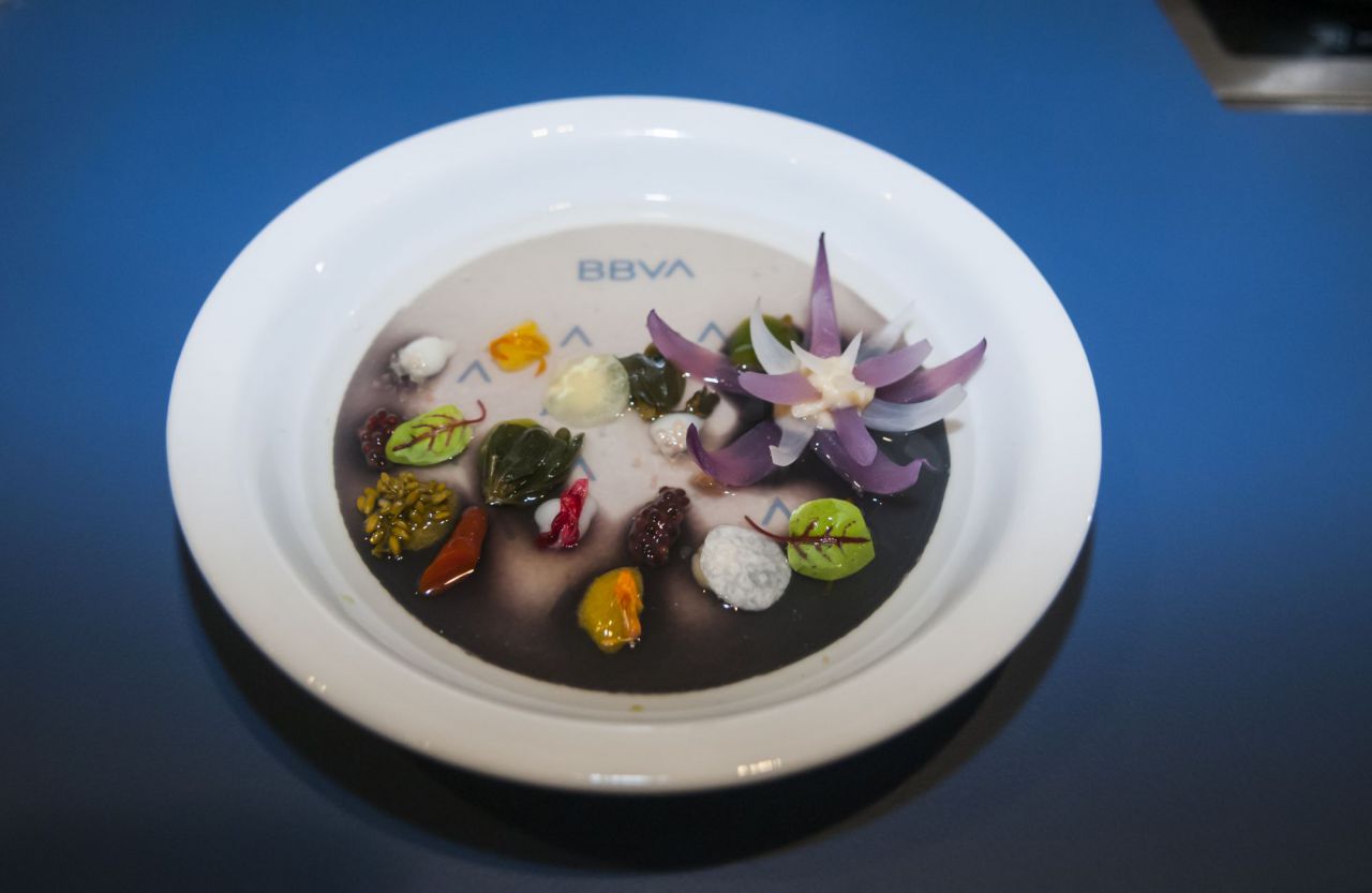 Gracias a un principio cromotérmico del plato, la sopa que ha acompañado a la flor de cebolla y las flores y tallos encurtidos ha cambiado de color el fondo, donde ha aparecido la nueva identidad de marca de BBVA. 