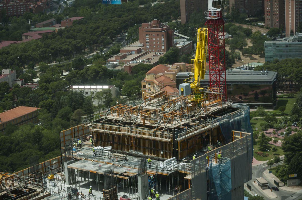 Grúas y obreros trabajan en la torre.