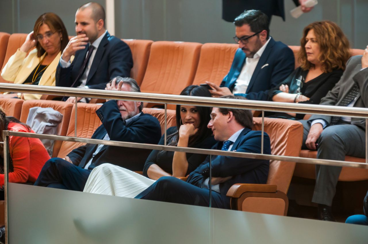 El alcalde y la vicealcaldesa de Madrid, Almeida y Villacís, intercambian comentarios en la tribuna de invitados. Al fondo, el concejal socialista, Pepu Hernández.