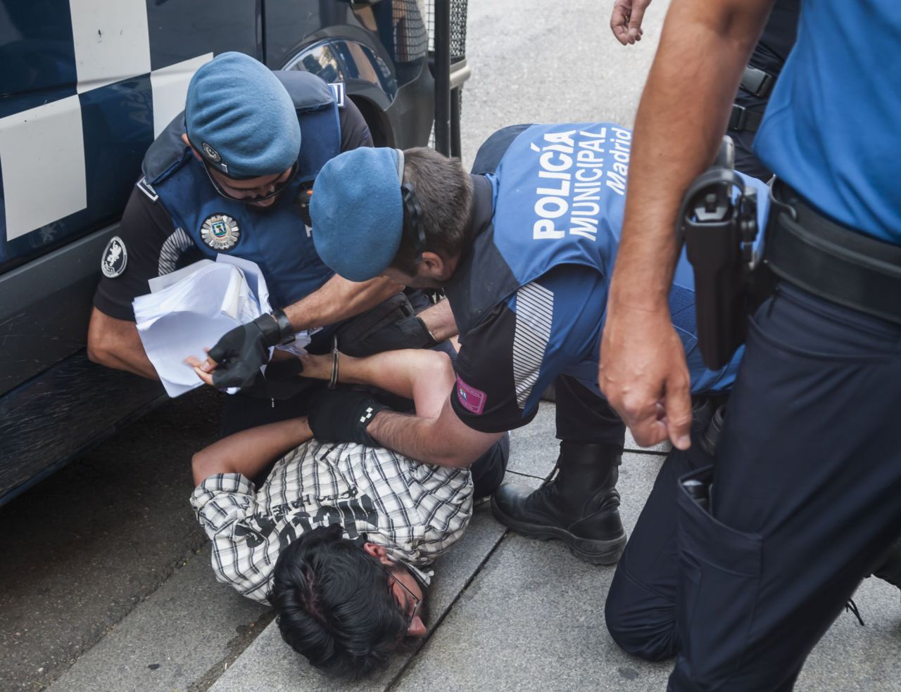 Los agentes le han reducido para esposarle. 