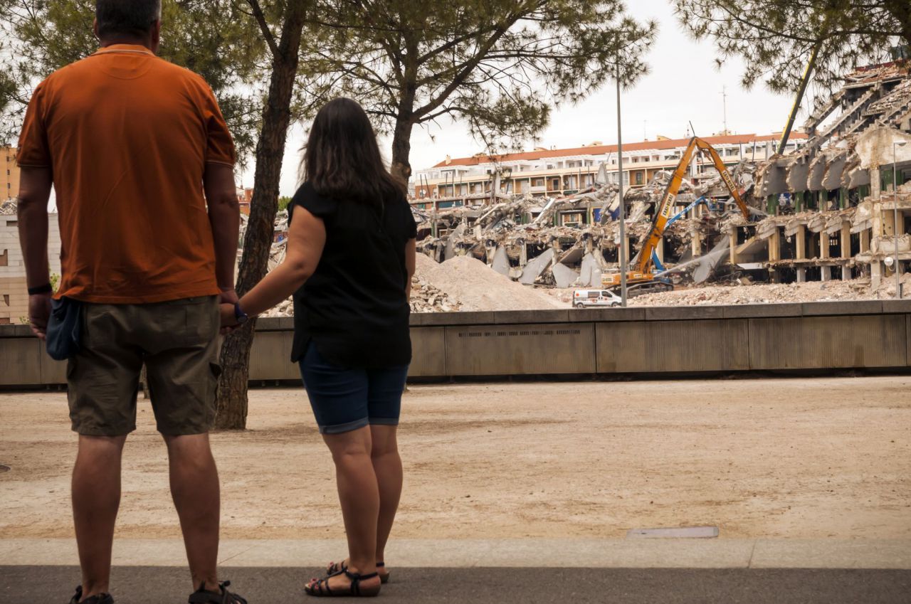 Una pareja observa, a lo lejos, el derribo del Calderón.