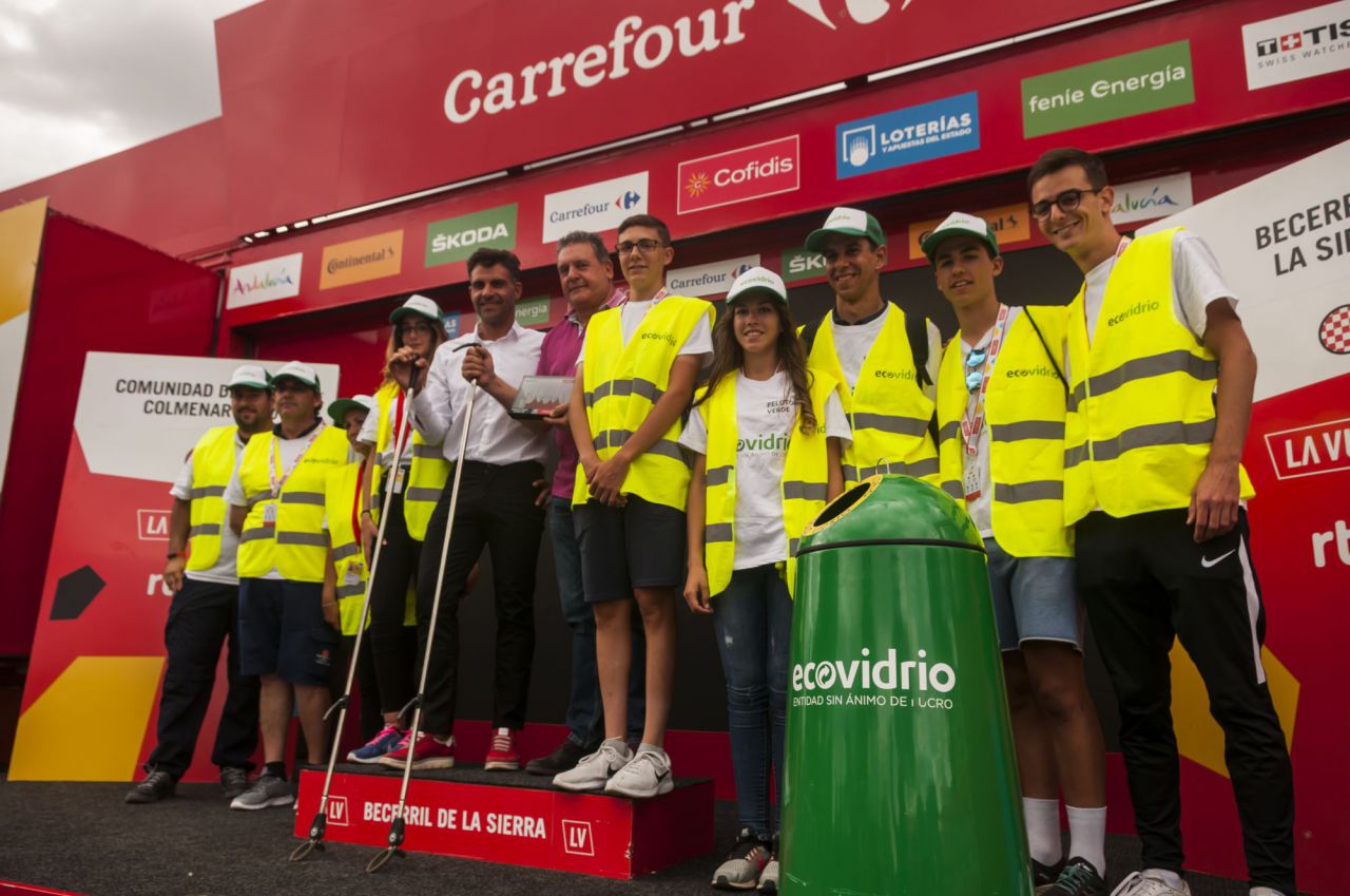 El Pelotón Verde recoge los residuos del último kilómetro de la etapa 18 de La Vuelta, que terminó en Becerril de la Sierra. En la foto posan en el pódium.