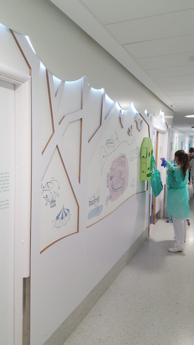 Una de las enfermeras va a entrar en una habitación en aislamiento a atender a un niño hospitalizado