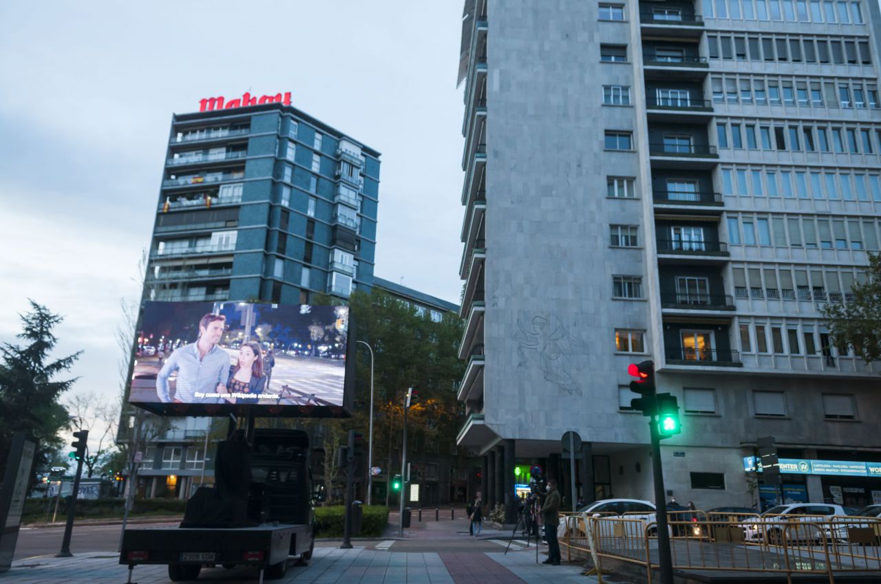 Una furgoneta, desplaza por Madrid,emitir ,películas,ver,desde los balcones.