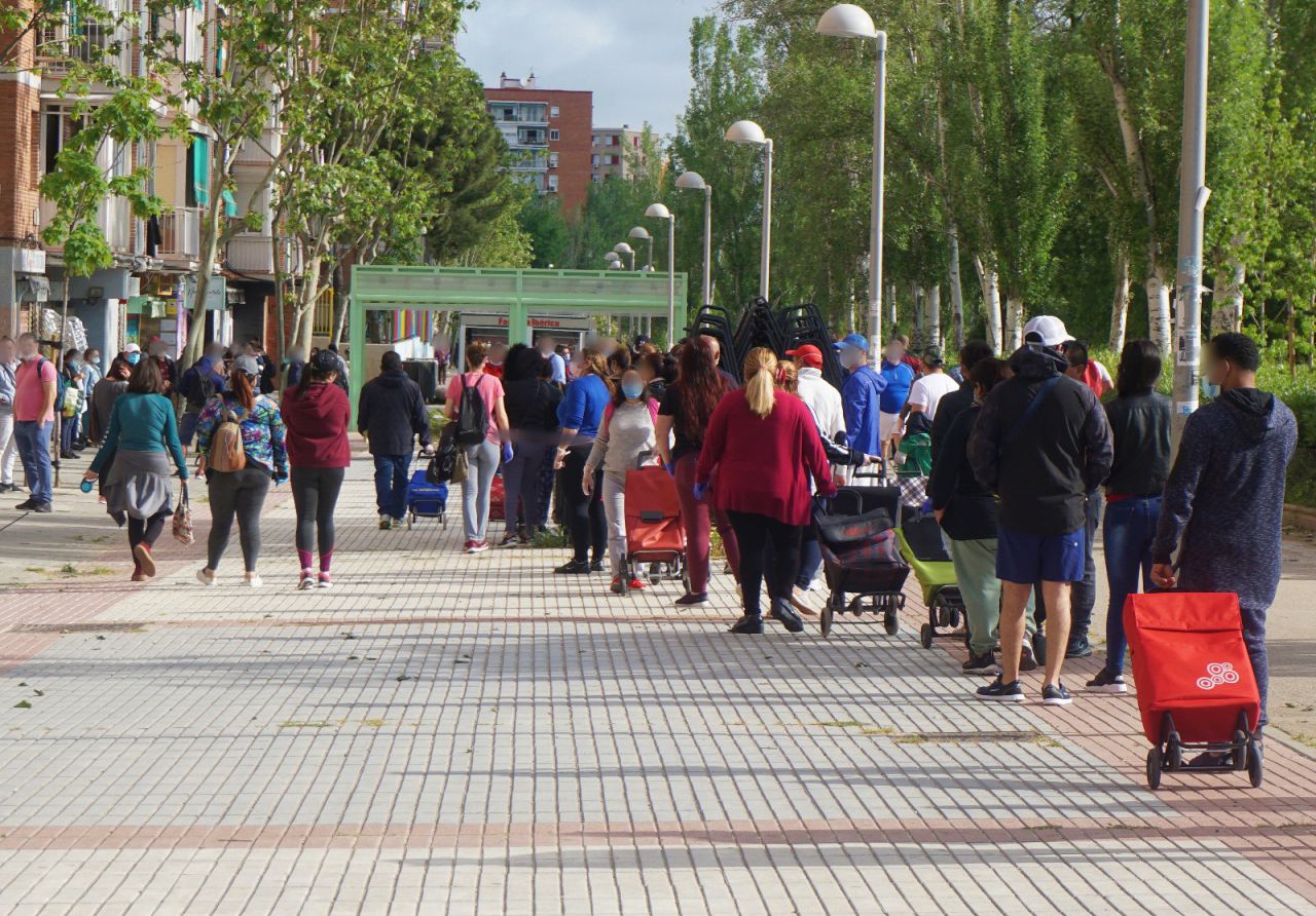 Centenares de personas hacen cola cada fin de semana para recoger alimentos en un local de Asociación de Vecinos de Aluche. 