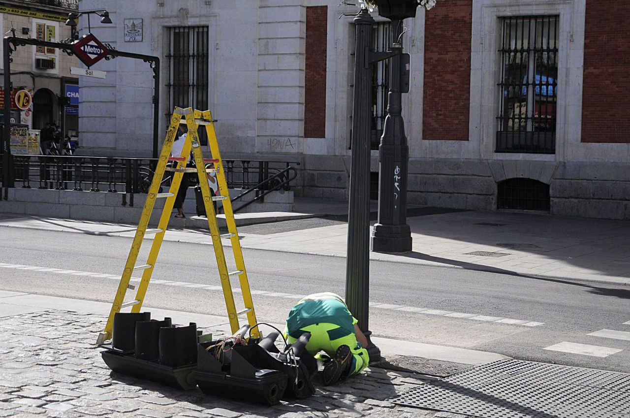 Un operario retira los semáforos de la calle Mayor a su paso por la Puerta del Sol 