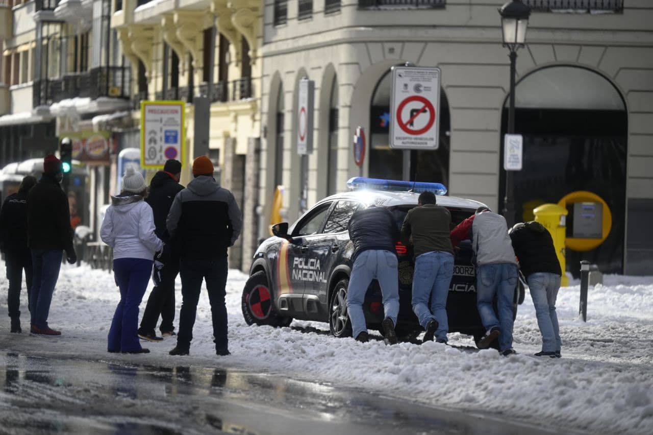 Un coche de la Policía Nacional atrapado por la nieve en una calle de Madrid