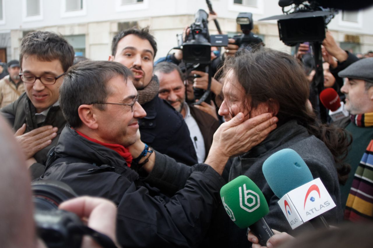 Juan Carlos Monedero y Pablo Iglesias se saludan a la salida del pleno de constitución del Congreso de los Diputados.
