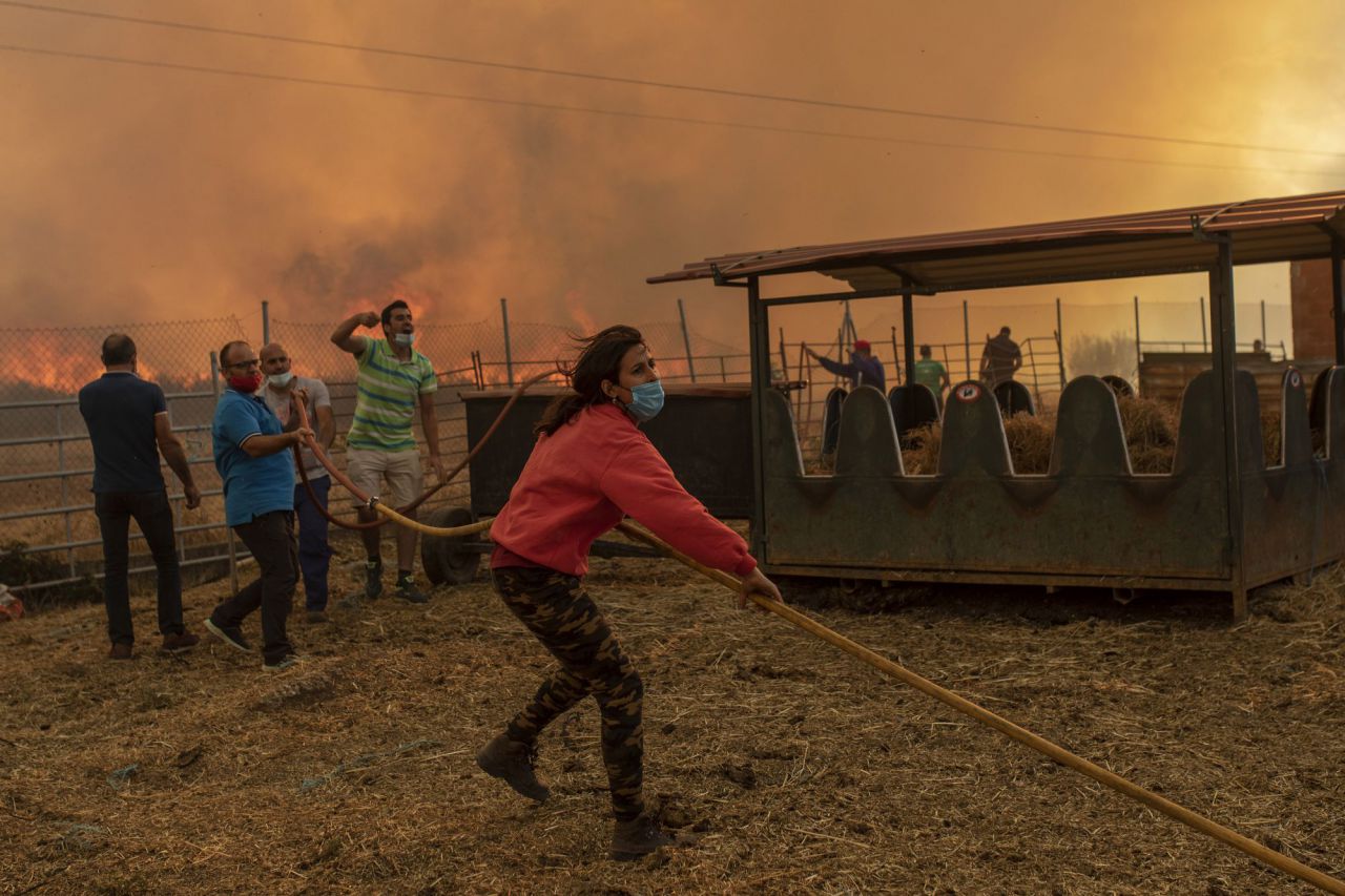 Una mujer ayuda en las tareas de extinción de un incendio cerca de una nave ganadera en Vegalatrave. Zamora, 15 de agosto de 2020.