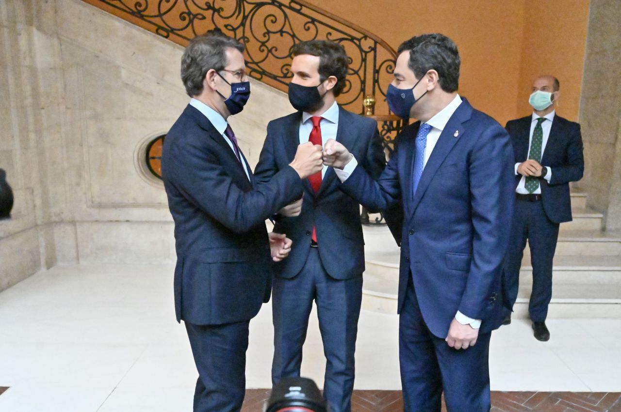 Pablo Casado, líder del Partido Popular, charla con Juanma Moreno, presidente de Andalucía, y Alberto Núñez Feijóo, presidente de Galicia, minutos antes de la toma de posesión de Isabel Díaz Ayuso como presidenta de la Comunidad de Madrid