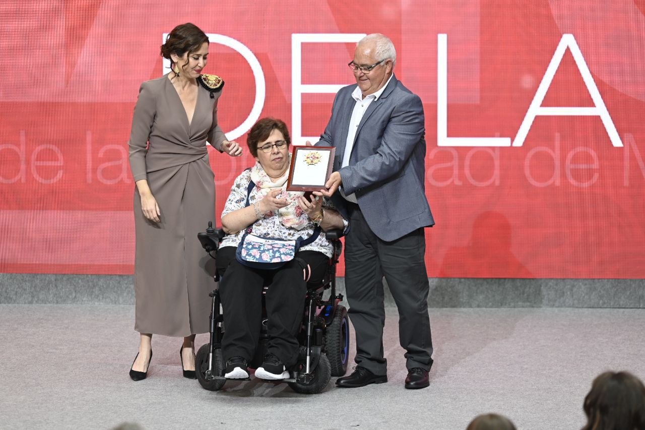 Isabel Díaz Ayuso entrega la Gran Cruz de la Orden del 2 de Mayo a Jacinto Tapusa, obrero de la construcción, acompañado por su mujer, doña Remedios Pérez