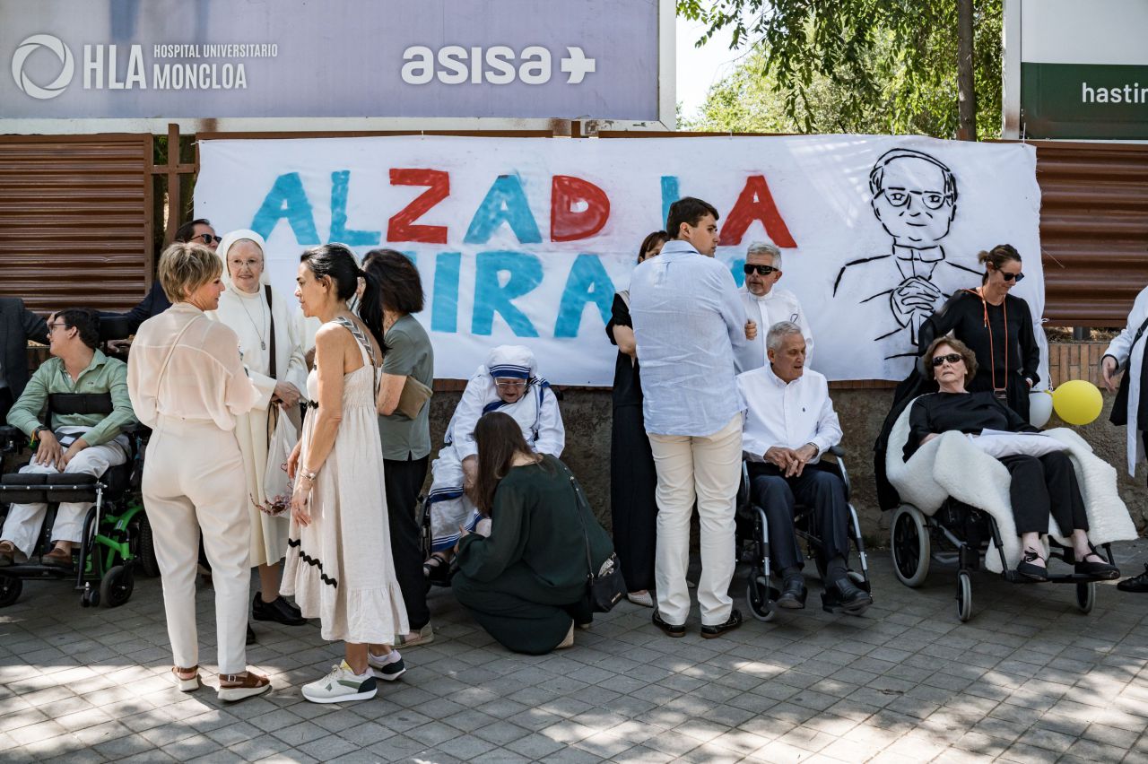 Varias personas ante una pancarta con el lema 'Alzad la mirada' en los exteriores de la sede de la Nunciatura Apostólica