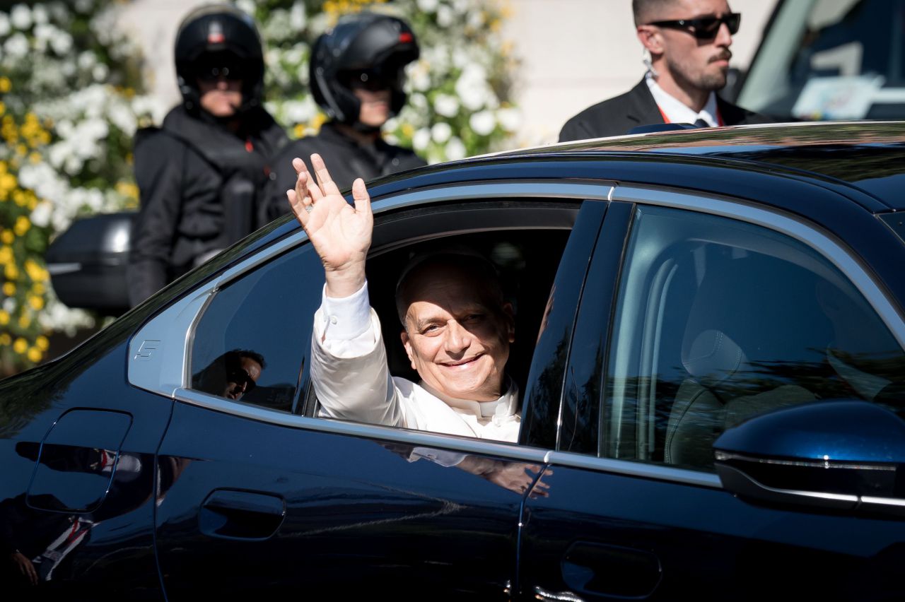 El Papa LEón XIV saludando desde su coche a la llegada del centro de Cáritas.