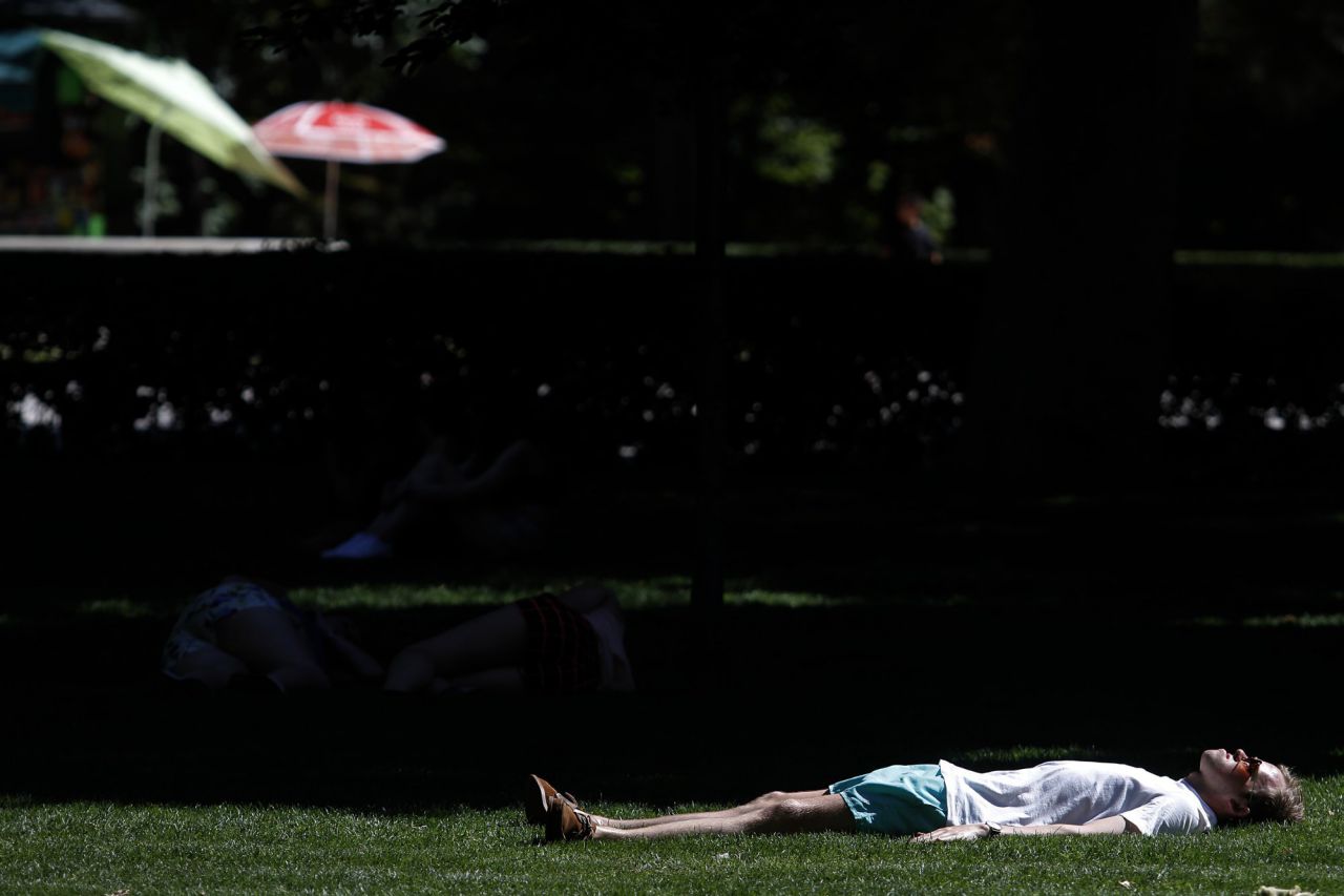 Un hombre tomando el sol en el Parque del Retiro.